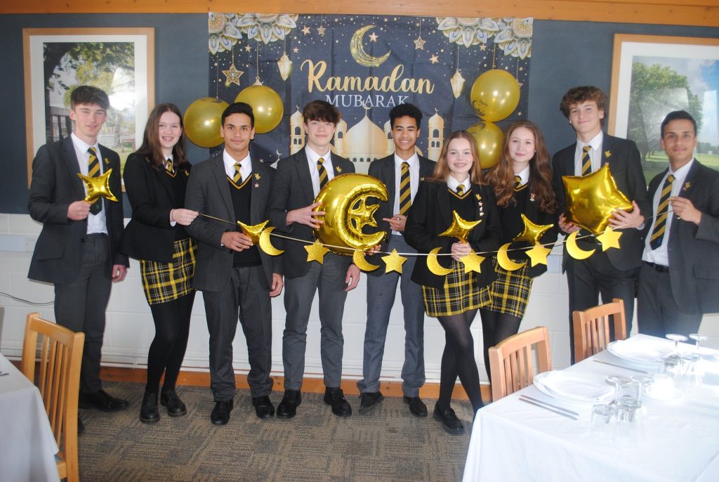 student standing by a Ramadan banner